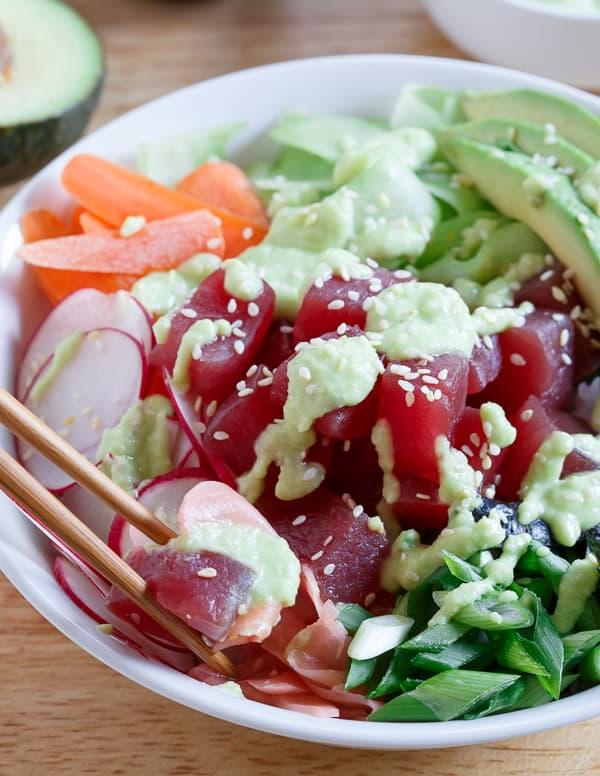 Ένα γρήγορο και εύκολο sushi bowl τόνου γεμάτο με ραπανάκια, καρότα, αγγούρι, φύκια και αβοκάντο, και περιχύνεται με μια πικάντικη σάλτσα αβοκάντο-wasabi.