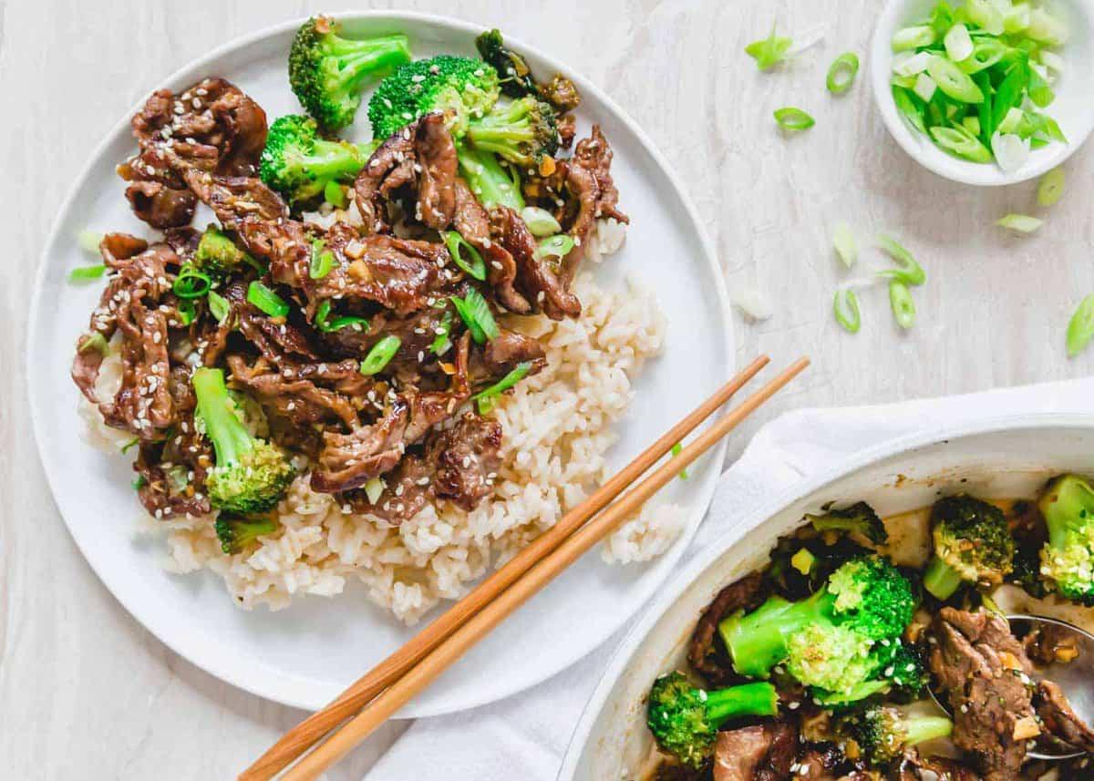 **Wok: 23 Ασιατικά Πιάτα που θα ξεπεράσουν το Takeout** 5 Stir fry μοσχάρι και μπρόκολο σερβιρισμένο με λευκό ρύζι σε ένα λευκό πιάτο.