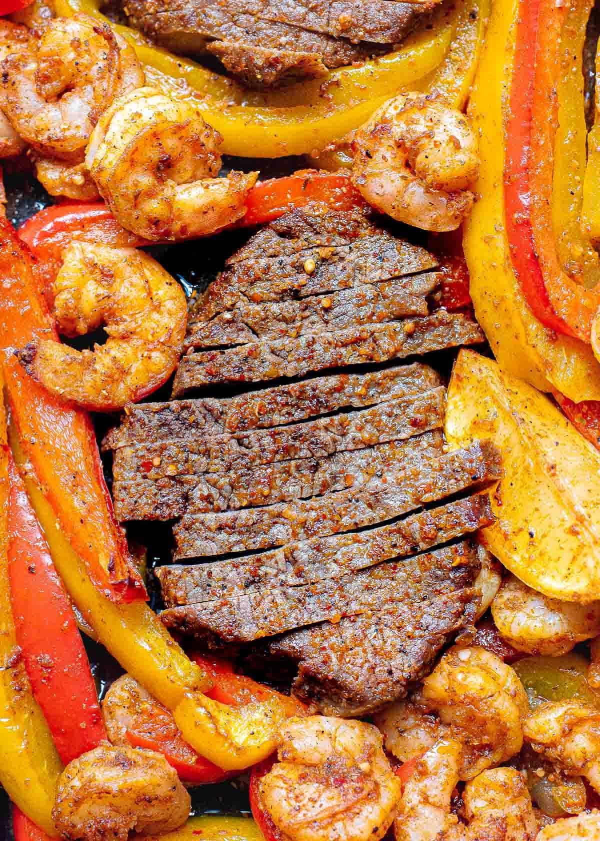 Sliced fajita steak with shrimp, peppers and onions. Sliced fajita steak with shrimp, peppers and onions.