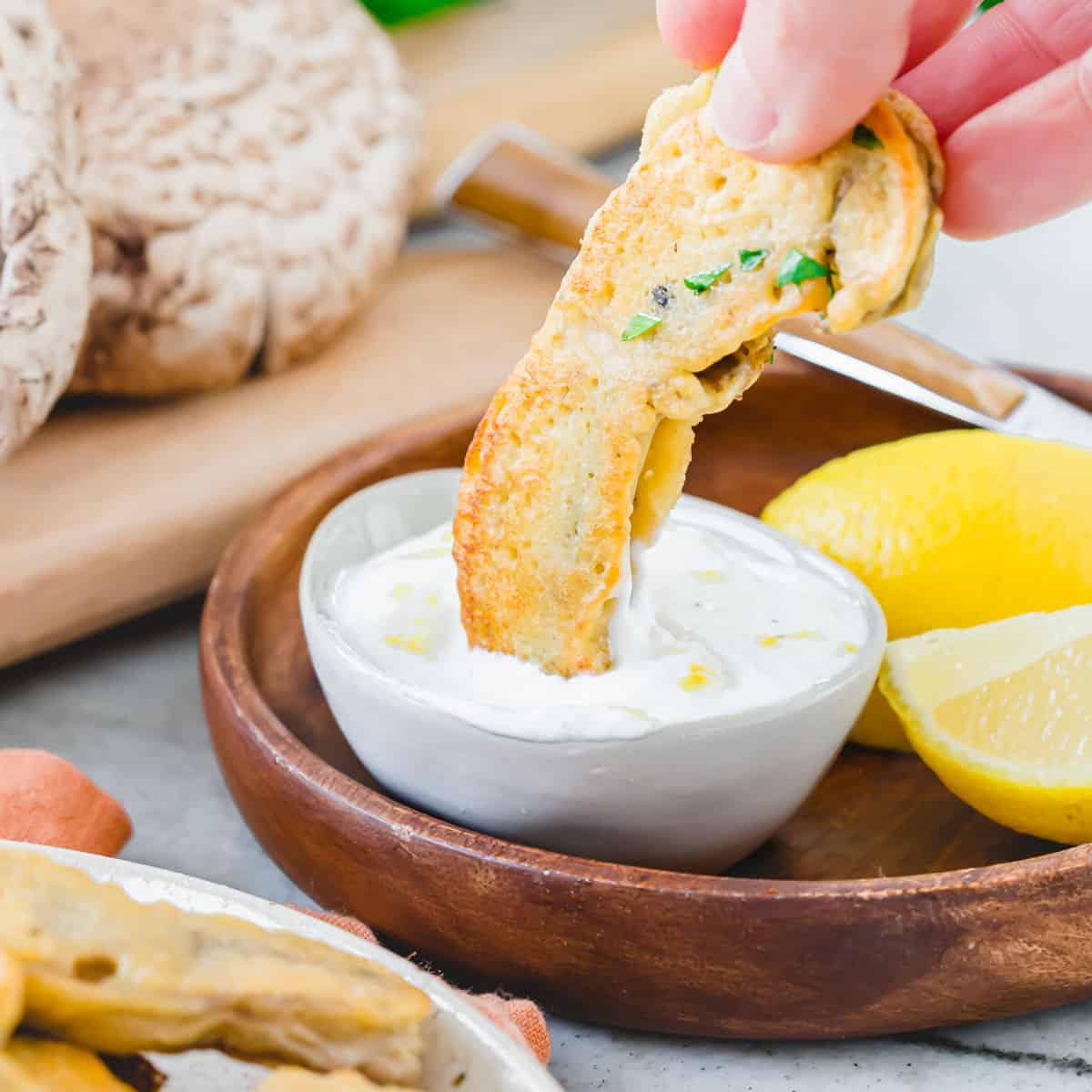 Απόλαυση με Σάλτσα Γιαουρτιού και Λεμονιού Βουτώντας ένα τηγανητό μανιτάρι Portobello σε σάλτσα γιαουρτιού με λεμόνι.