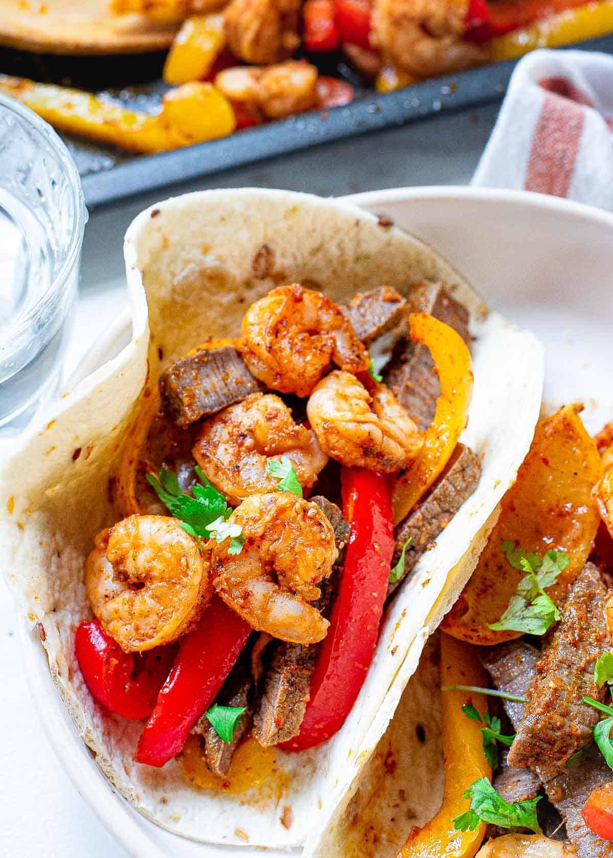 Steak and shrimp fajitas made made on a sheet pan. Steak and shrimp fajitas made made on a sheet pan.