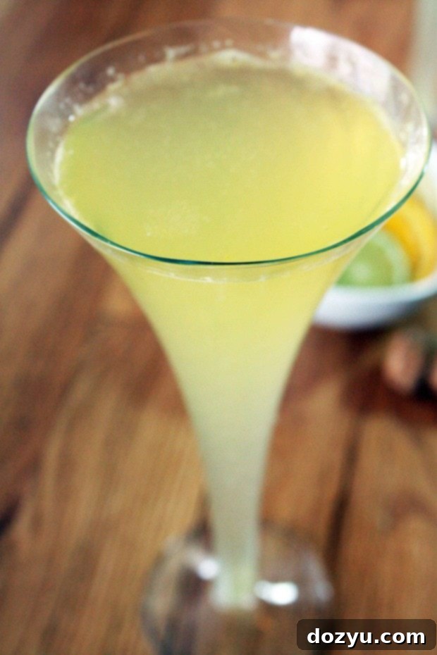 Refreshing Limoncello Sparkler 2 A vibrant Limoncello Sparkler cocktail in a stylish coupe glass, garnished with an elegant lemon twist, perfectly highlighting its bright yellow hue and inviting presentation.