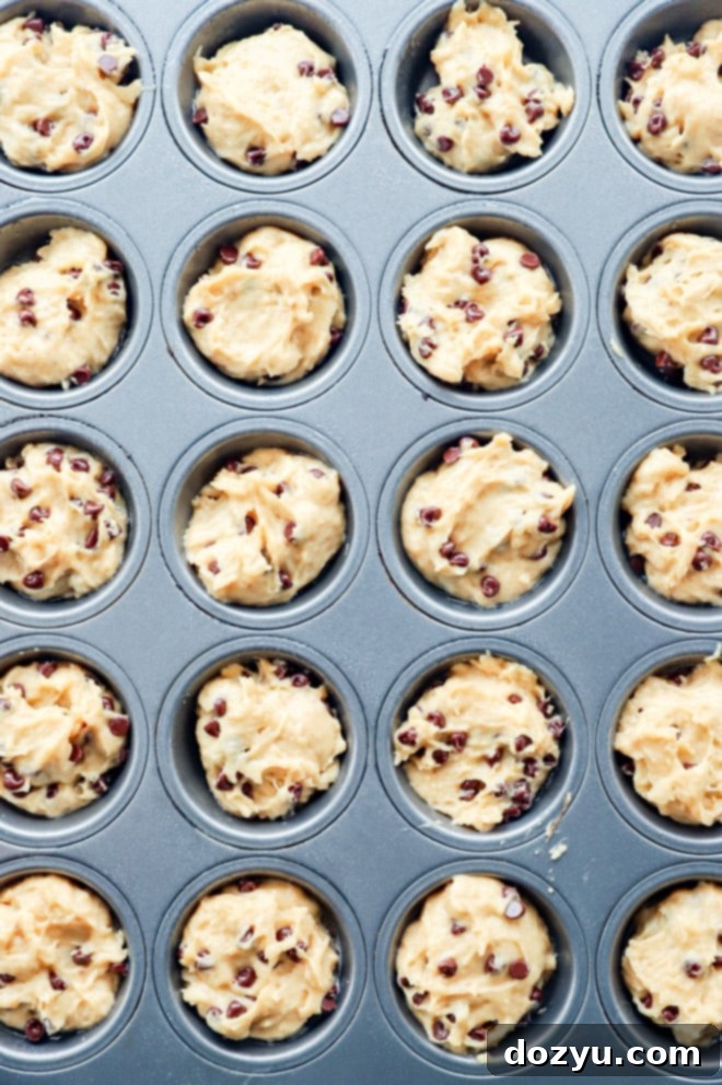 Perfectly Poppable Banana Peanut Butter Chocolate Muffins 5 Close-up of mini banana muffin batter being scooped into a mini muffin tin
