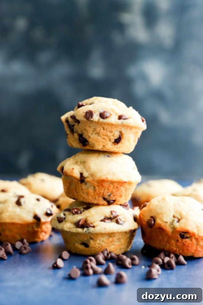 Perfectly Poppable Banana Peanut Butter Chocolate Muffins 6 A stack of golden brown mini banana peanut butter chocolate chip muffins on a wire rack