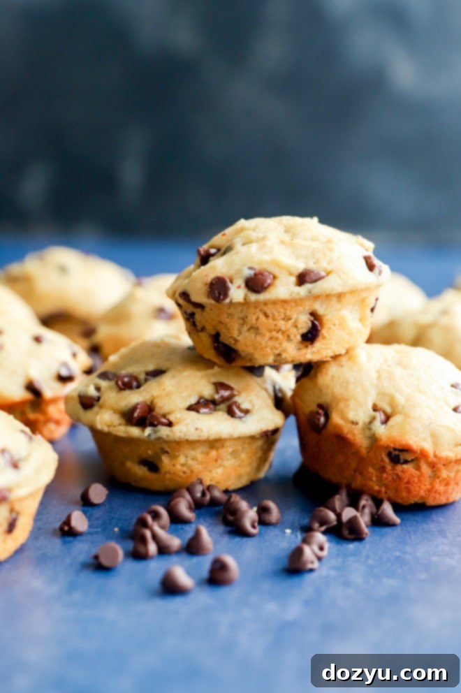 Perfectly Poppable Banana Peanut Butter Chocolate Muffins 8 A stack of golden brown mini banana peanut butter chocolate chip muffins with visible chocolate chips