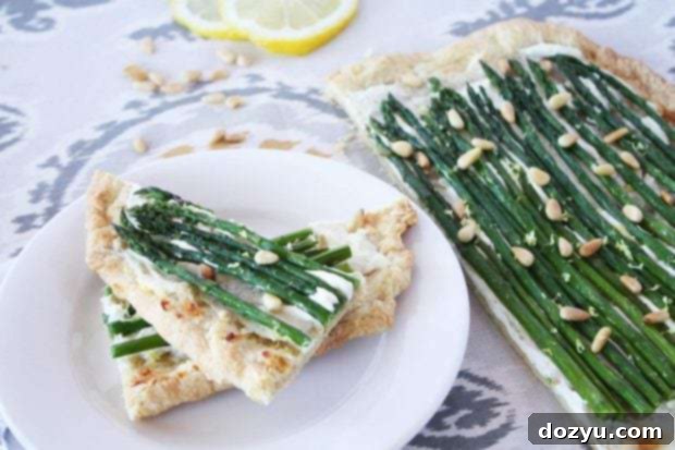 Spring Asparagus Goat Cheese Tart 2 A slice of Asparagus Goat Cheese Tart on a white plate with fresh asparagus beside it