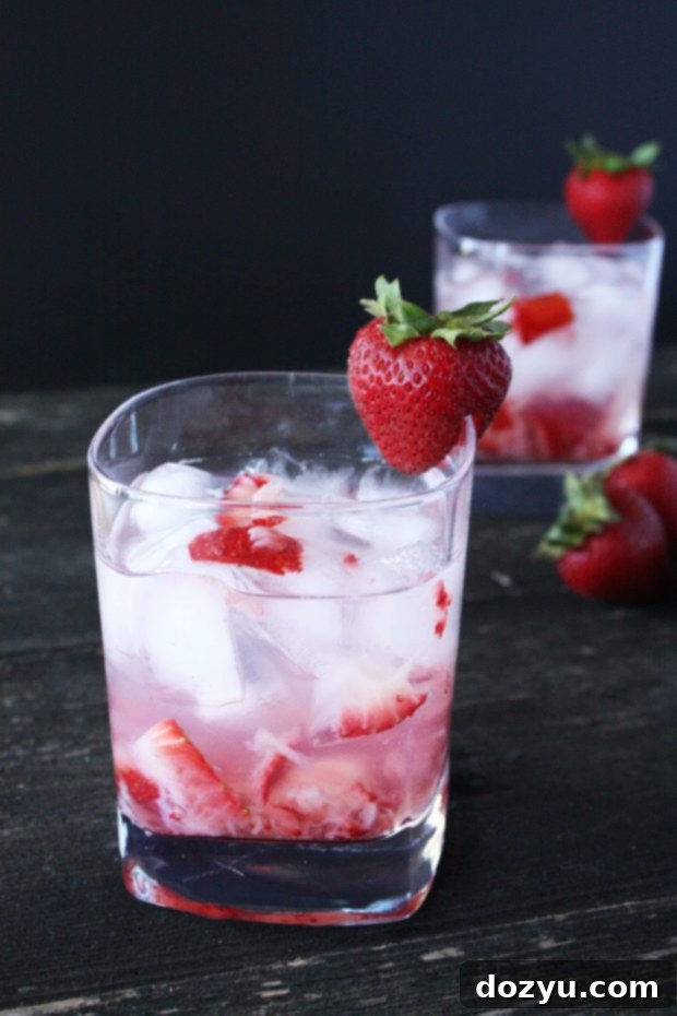 Velvet Berry Indulgence 2 A refreshing Strawberries & Cream Cocktail garnished with a fresh strawberry, recipe details included below.