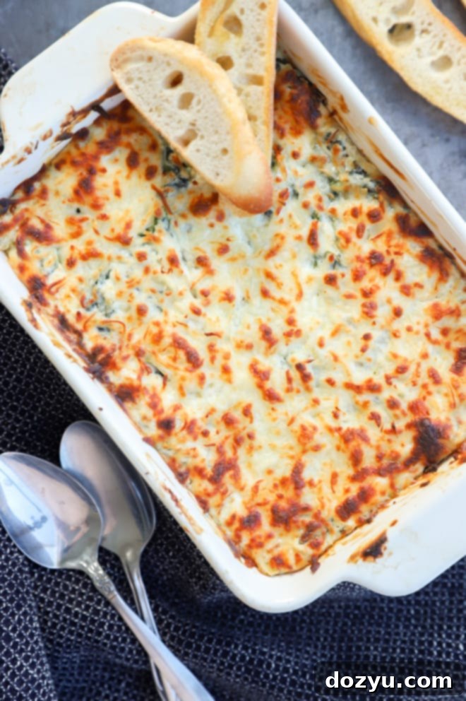 Creamy Spinach and Artichoke Goat Cheese Dip 3 Hot and bubbly spinach and artichoke goat cheese dip in a white casserole dish