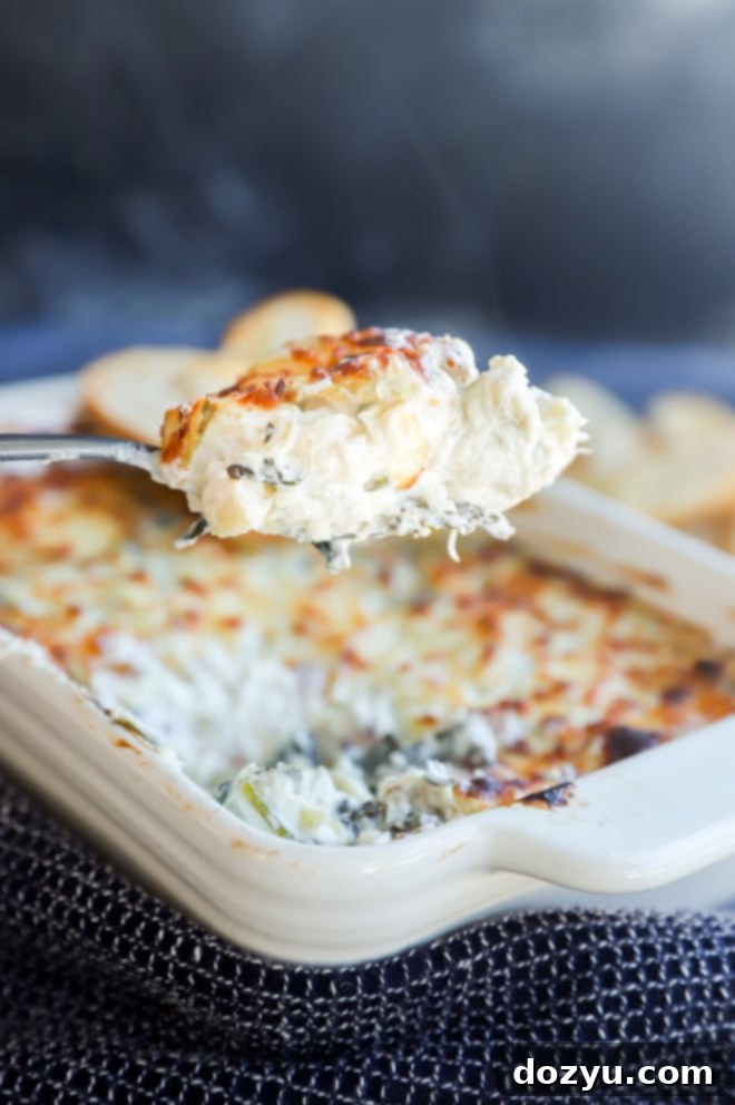 Creamy Spinach and Artichoke Goat Cheese Dip 4 Close-up of a spoonful of hot, gooey spinach and artichoke goat cheese dip