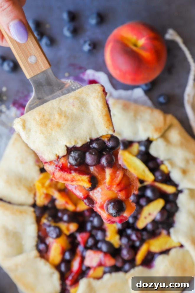 Rustic Peach Blueberry Galette 12 Picture of holding slice of galette with fresh fruit in hand