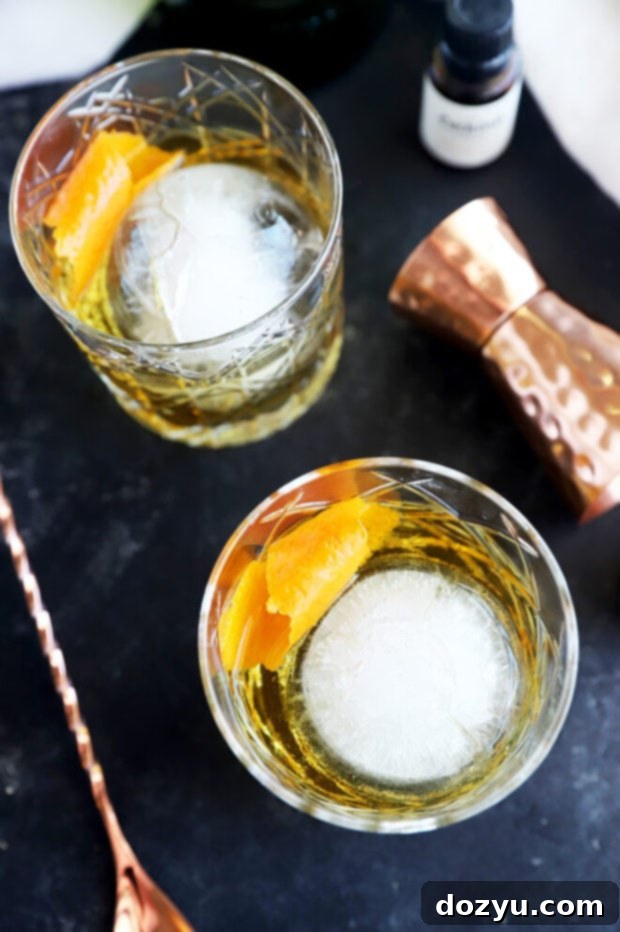 Jameson's Enduring Classic 7 Overhead photo of two Jameson Old Fashioned cocktails in rocks glasses, garnished with orange peels and spheres of ice.