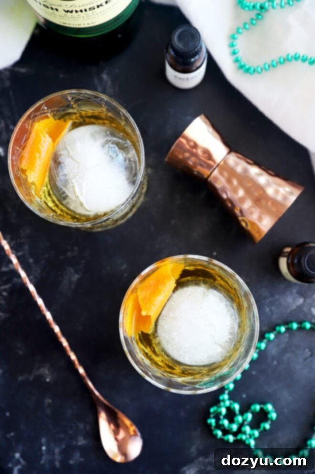 Jameson's Enduring Classic 9 Two Jameson Old Fashioned cocktails in rocks glasses with orange garnishes, photographed from a slightly elevated angle.