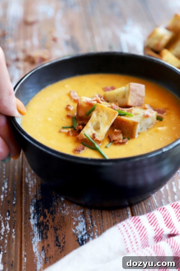 Golden Butternut Bliss with Smoky Bacon Crunch 5 Hand hold bowl of squash soup image