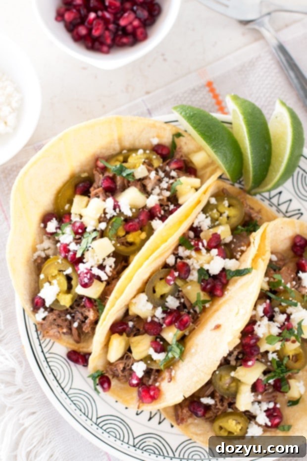 Close-up of succulent Pomegranate Pulled Pork in a slow cooker, ready to be shredded.