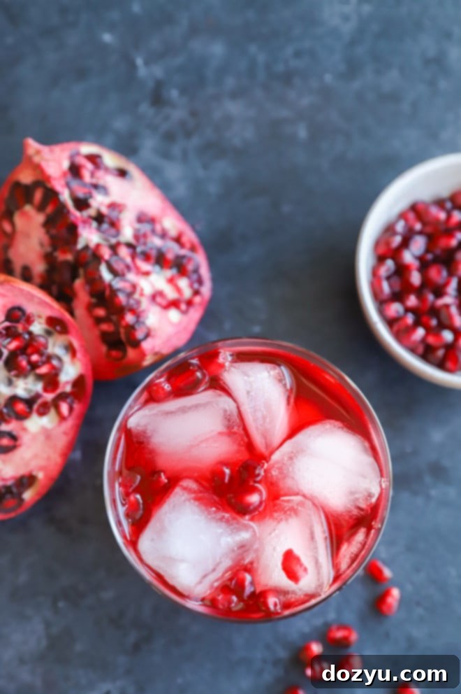 The Pomegranate Negroni 7 A festive Pomegranate Negroni cocktail surrounded by fresh pomegranates and winter greenery, highlighting its seasonal appeal.