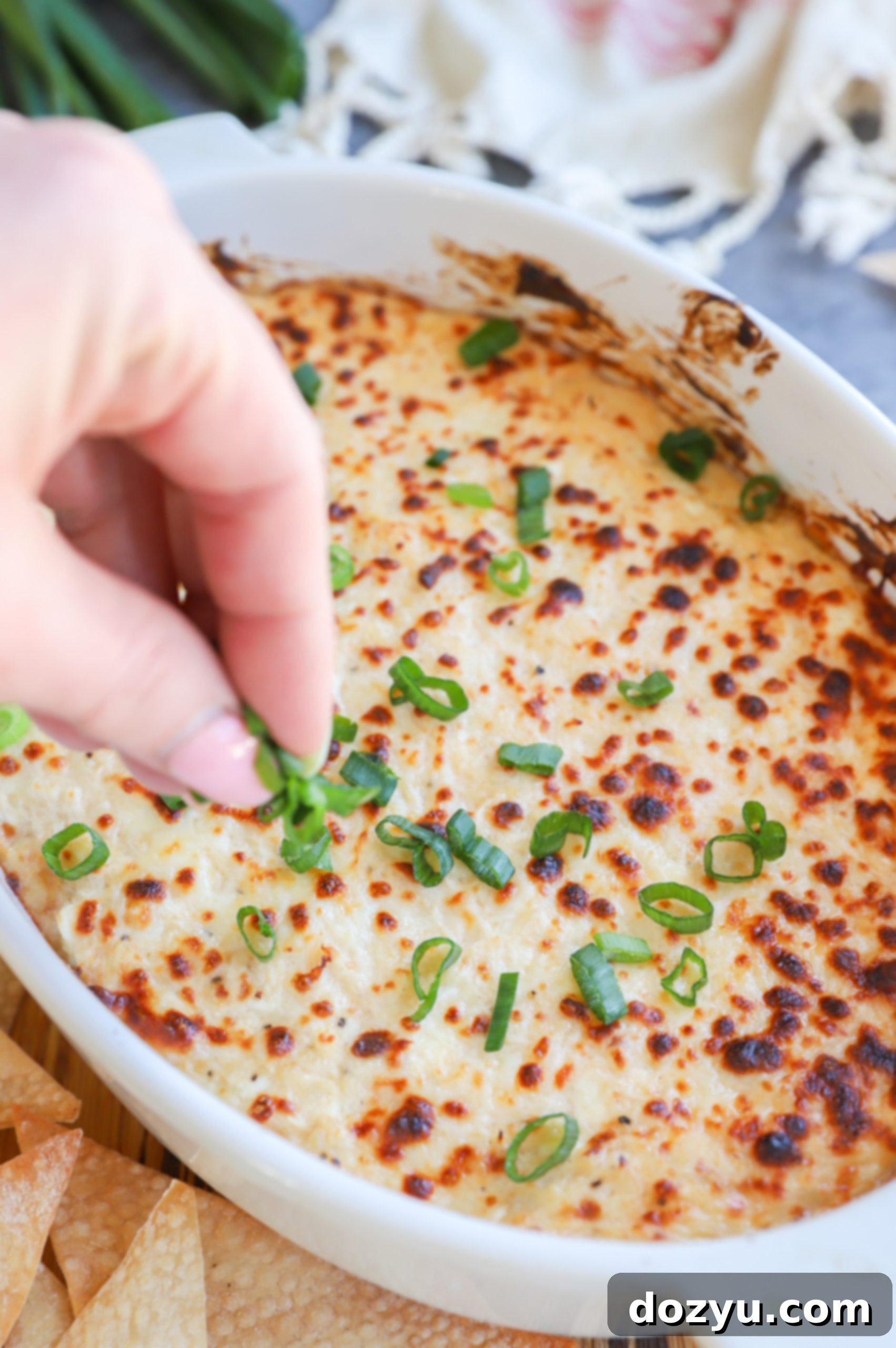 Creamy Crab Rangoon Dip with Crispy Wonton Dippers 5 Garnishing cheese dip with green onions image