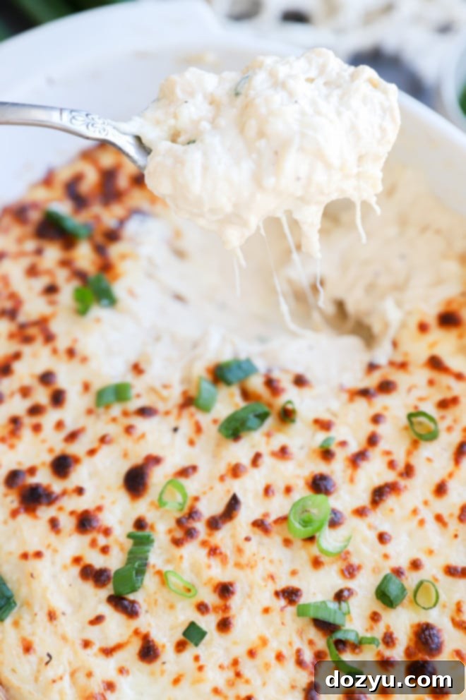 Creamy Crab Rangoon Dip with Crispy Wonton Dippers 6 Spoon lifting out crab rangoon dip image