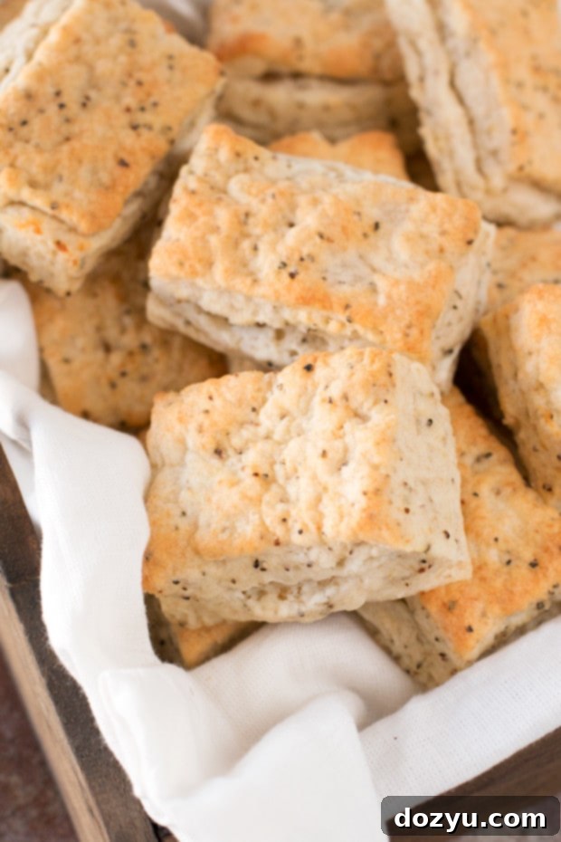 Close-up of a stack of fluffy Black Pepper Goat Cheese Biscuits, showing the texture and specks of pepper and cheese.