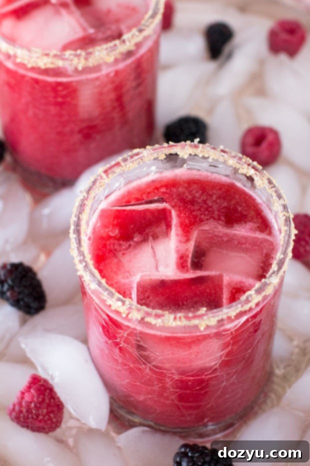 Mixed Berry Margarita in a glass with a sugar rim and fresh berry garnish, ready to be enjoyed.