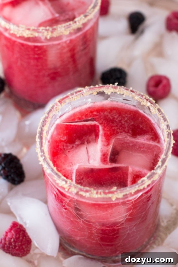 Mixed Berry Margarita garnished with an array of fresh berries and a lime wedge, ready for a spring or summer party.