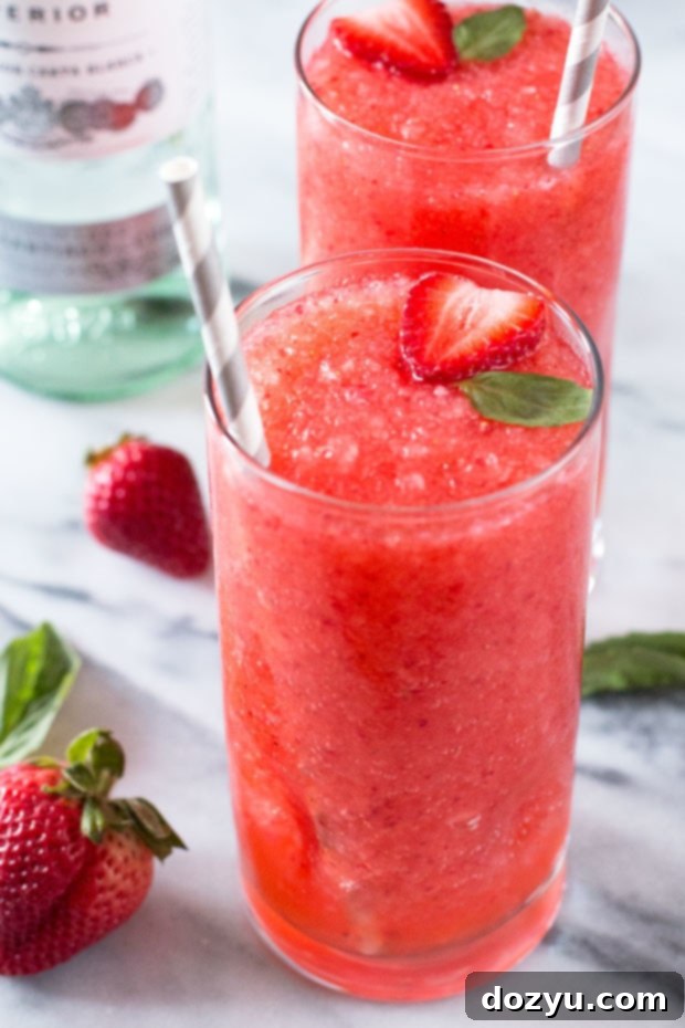 Close-up of a Strawberry Basil Frozen Daiquiri, highlighting its vibrant red color and fresh basil garnish