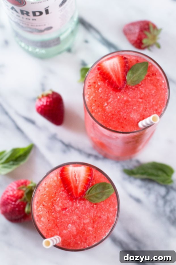 Three Strawberry Basil Frozen Daiquiris ready to be enjoyed on a bright day