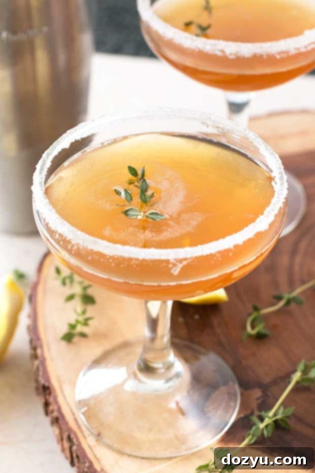 A close-up shot of a refreshing Lemon Thyme Sidecar, highlighting its vibrant colors.