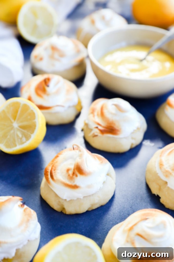 Lemon Curd Meringue Cookies 2 lemon curd cookies with meringue topping and lemon curd in a bowl, showcasing the dessert's delicious layers