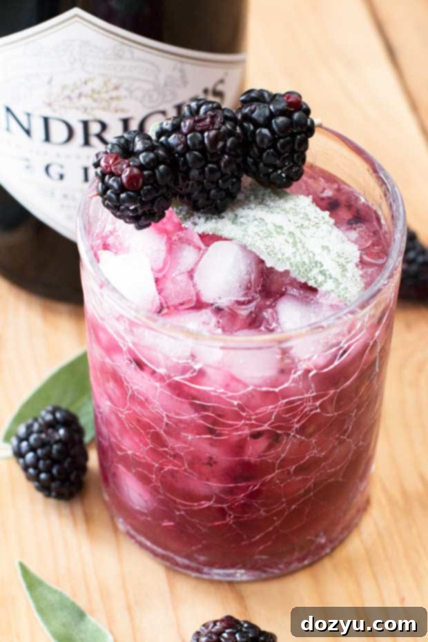 Delicious Blackberry Sage Gin Smash cocktail with fresh blackberries and candied sage leaves