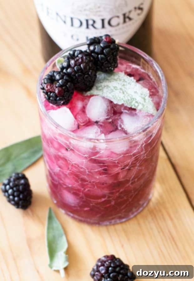 Close-up of a Blackberry Sage Gin Smash cocktail with ice and a blackberry garnish