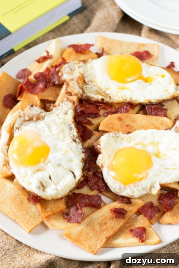 The Basque Book Unveiled Messy Eggs and Rough Cut Potatoes 2 A plate of Messy Eggs with Rough-Cut Potatoes, featuring perfectly fried eggs with runny yolks nestled among golden-brown potato shards and scattered chorizo pieces.