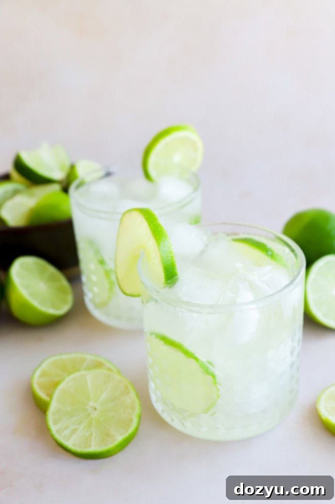 Sip of Brazil 2 caipirinha cocktails in glasses with fresh limes all around