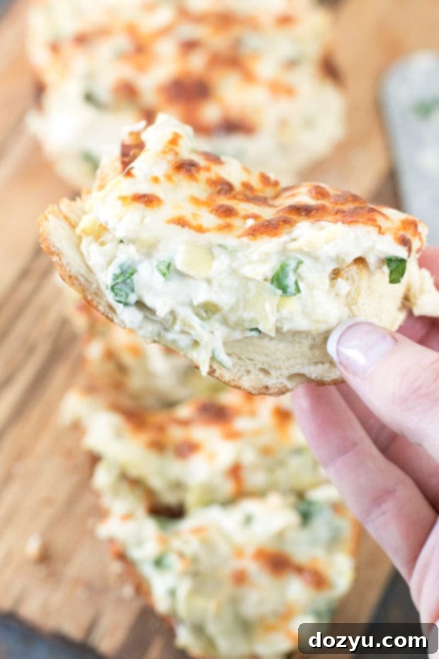 Cheesy Chicken Spinach & Artichoke Dip French Bread on a serving board | cakenknife.com