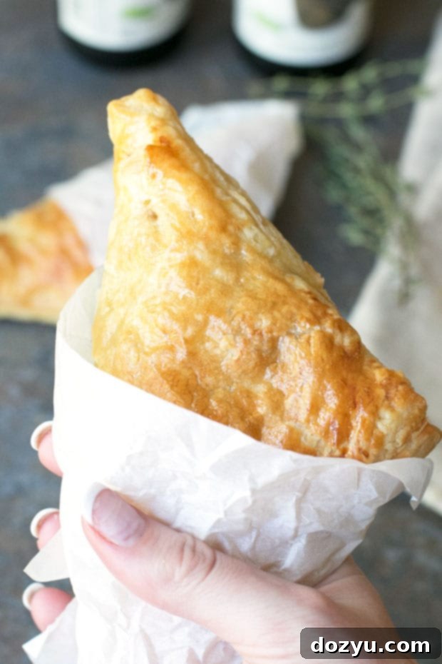 Close-up of a Black Pepper Steak Hand Pie on a rustic surface.