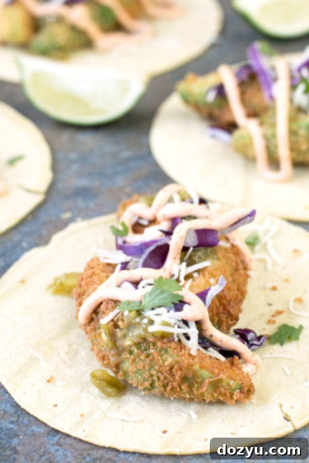 Crispy Fried Avocado Tacos topped with fresh ingredients and a drizzle of chili lime dressing
