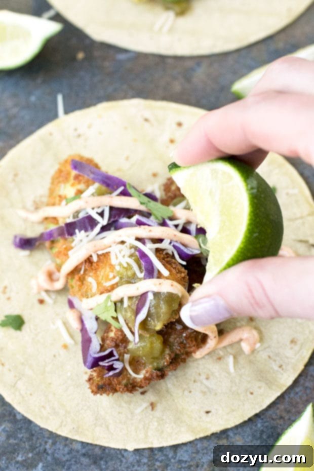 Garnished fried avocado tacos with a vibrant chili lime dressing drizzle