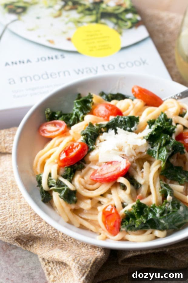 A Modern Way to Cook Review Highlighting Kale Tomato Lemon One Pot Spaghetti 4 A serving of Kale, Tomato, and Lemon One-Pot Spaghetti, garnished with fresh lemon zest and a sprinkle of Parmesan.