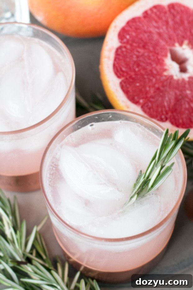 Verdant Blush Fizz 5 Rosemary Grapefruit Gin Fizz cocktail with a rosemary sprig garnish