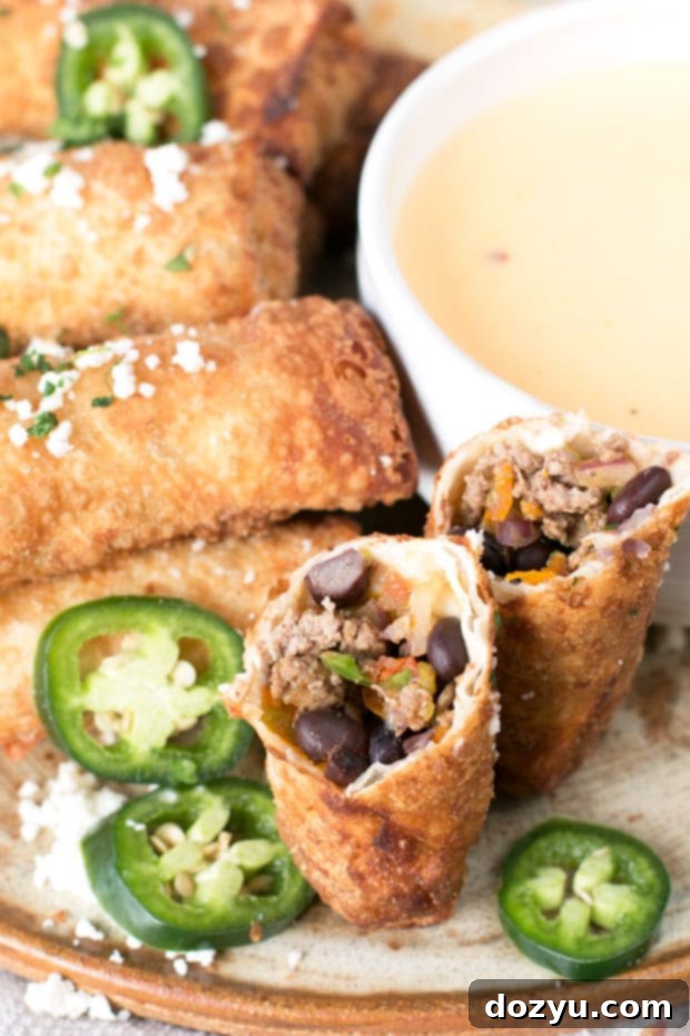 Close-up of a perfectly fried Loaded Nacho Egg Roll with molten cheese filling, ready to be dipped