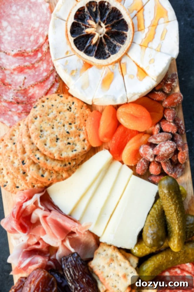 brie with hot honey and other cheeses, meats, and extras on an easy charcuterie board