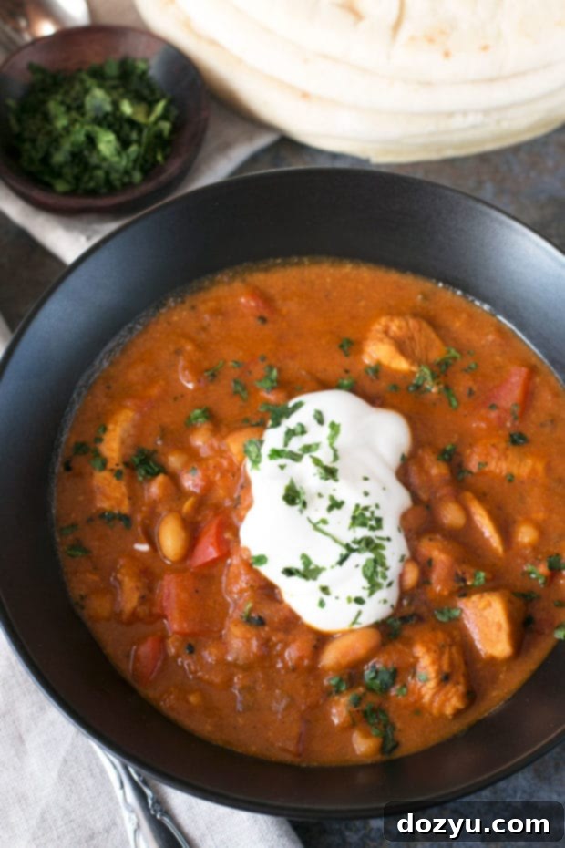 Rich and creamy Tikka Masala Chicken Chili served in a bowl with cilantro and naan bread – a perfect Indian-inspired comfort food fusion