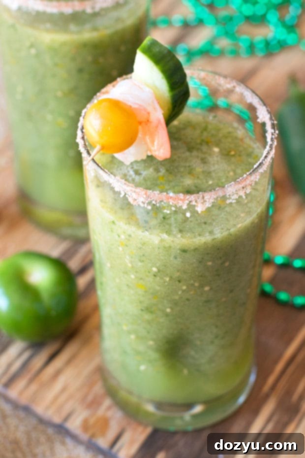 Close-up of a vibrant Spicy Green Bloody Mary cocktail, garnished with a fresh lime wedge and a yellow tomato, in a tall glass, perfect for a sunny brunch.