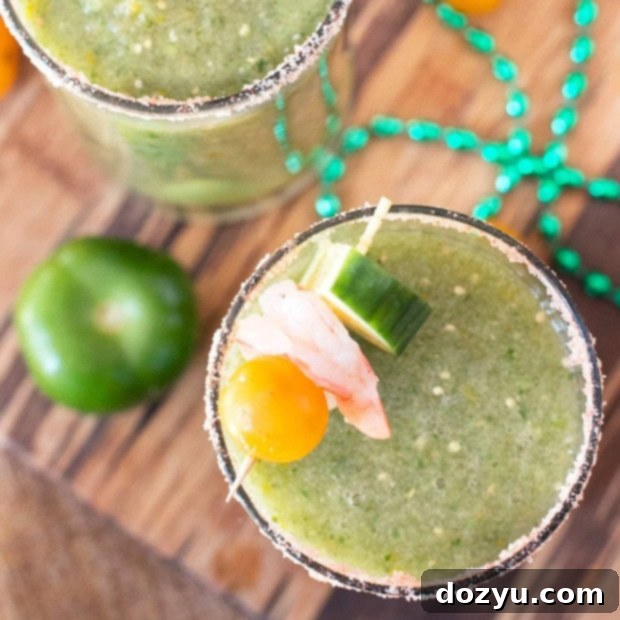 Emerald Spice Mary 6 Thumbnail image of a Spicy Green Bloody Mary garnished with yellow tomatoes and a cucumber ribbon, on a rustic cutting board.