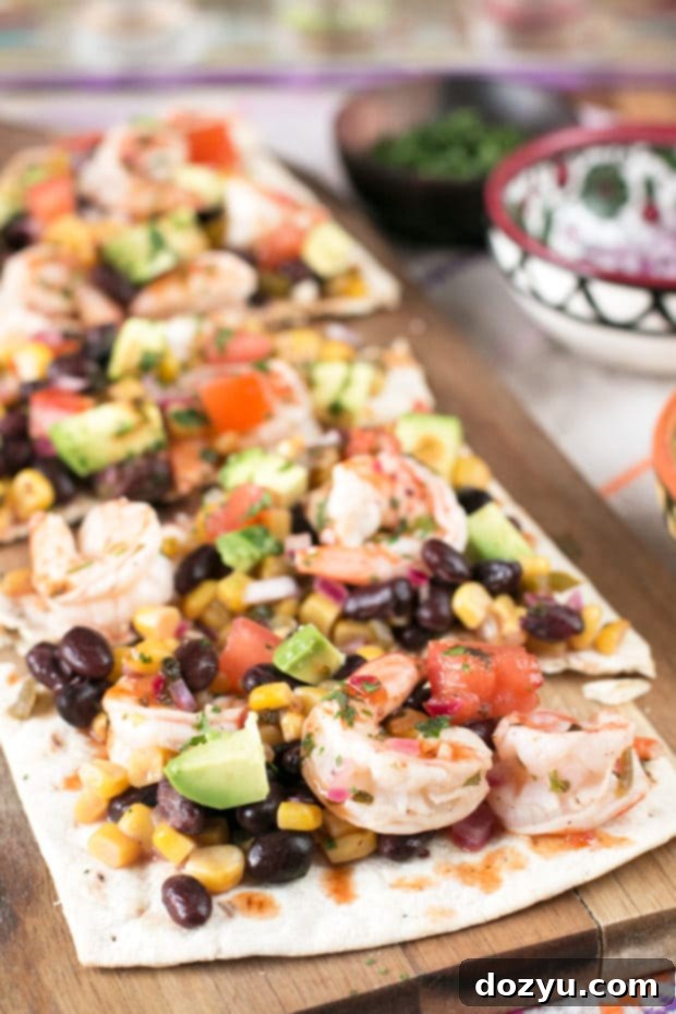 Zesty Southwestern Shrimp Flatbread 2 Southwestern Shrimp Flatbread with fresh vegetables and shrimp on a cutting board, perfect for an appetizer or party dish.