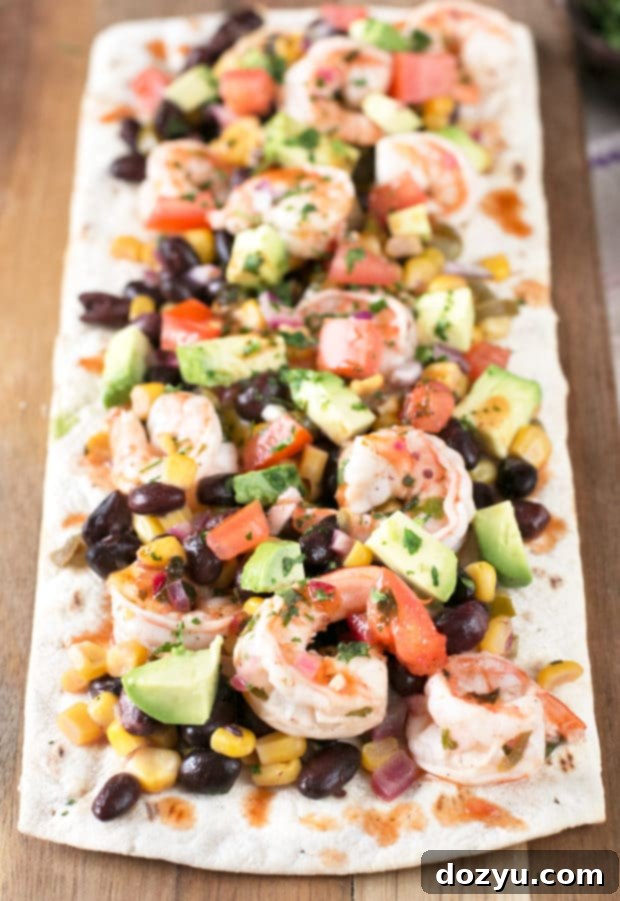 Zesty Southwestern Shrimp Flatbread 3 Close-up of a prepared Southwestern Shrimp Flatbread showcasing its vibrant toppings and crispy crust.