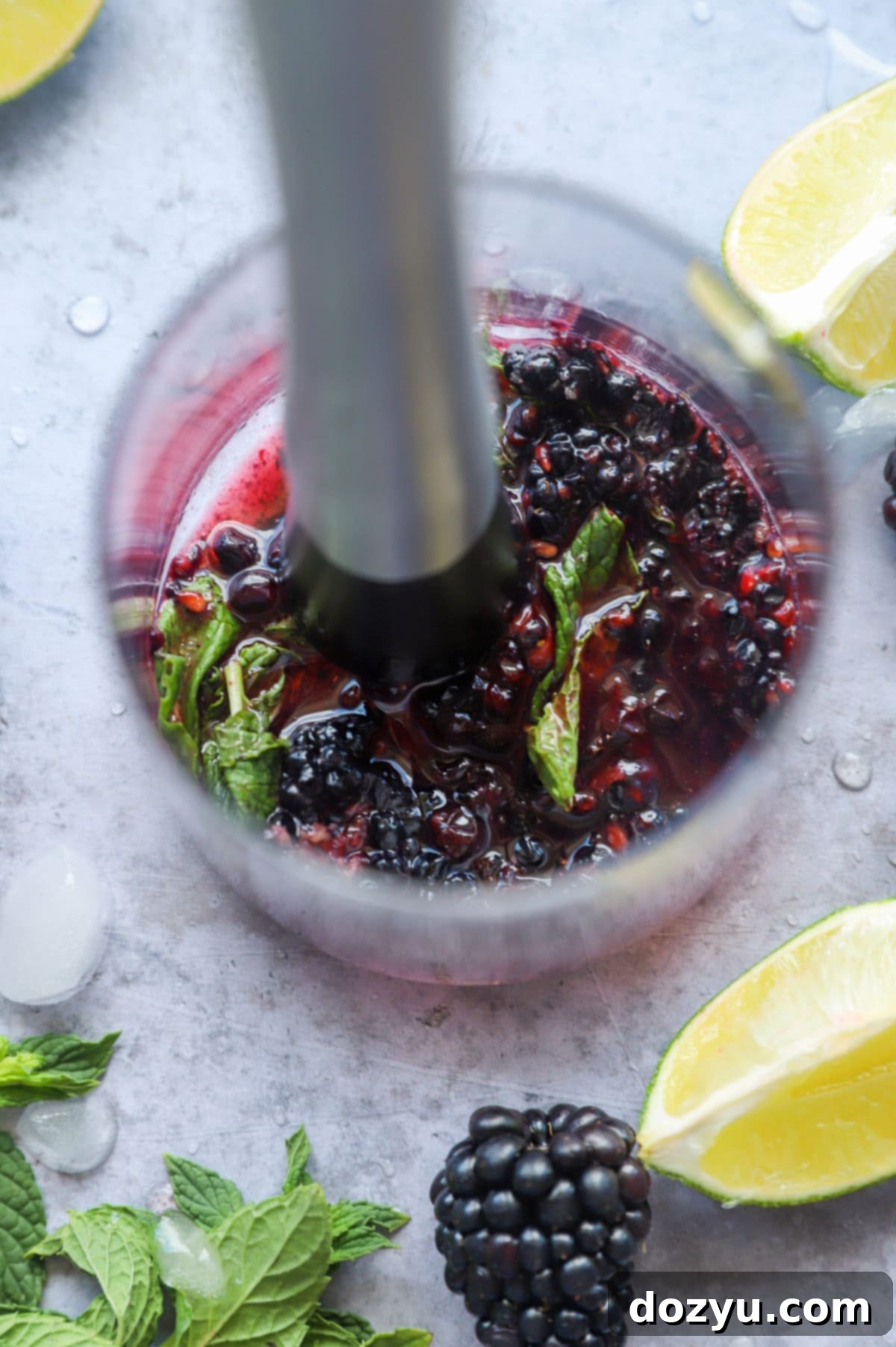 Blackberry Mojito 5 Muddle blackberries with mint in a cocktail glass image