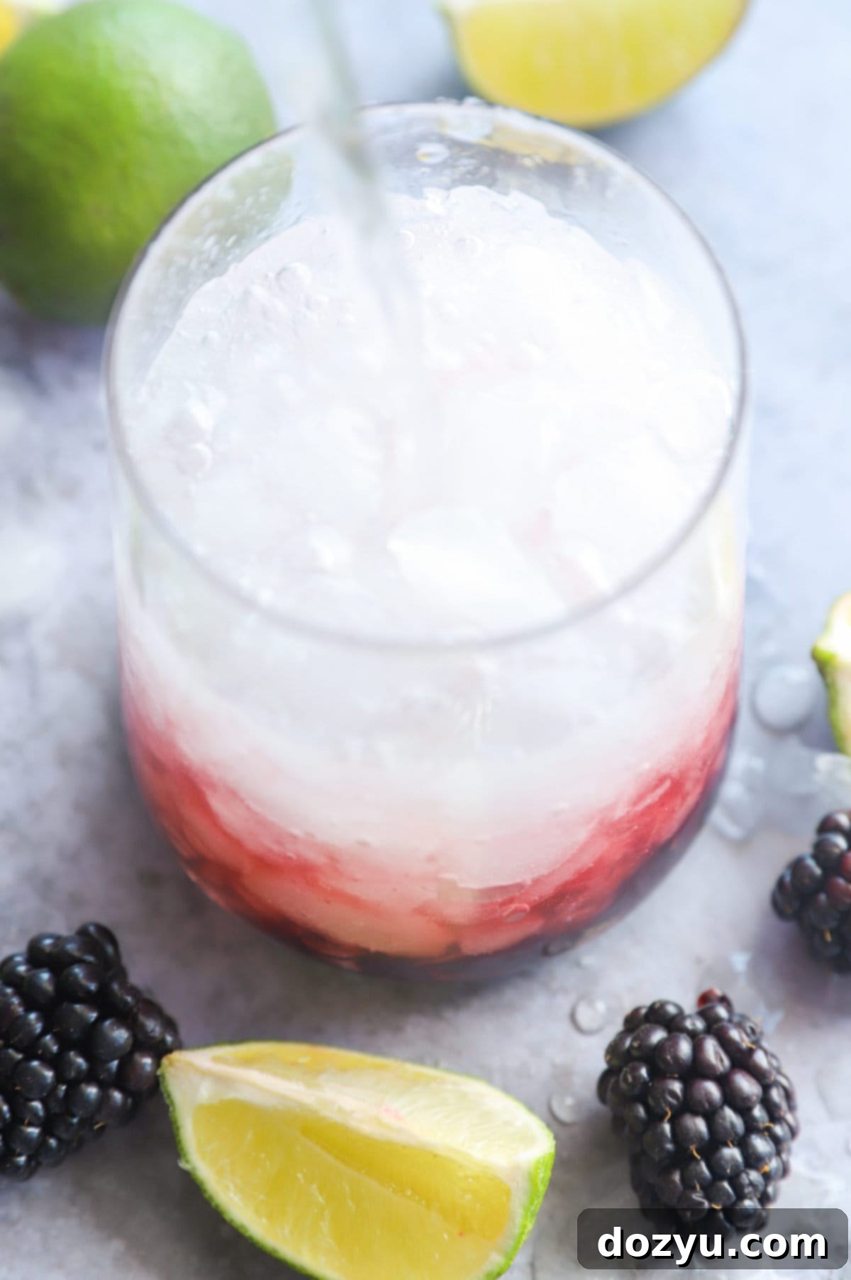 Blackberry Mojito 6 Pouring soda water into a cocktail
