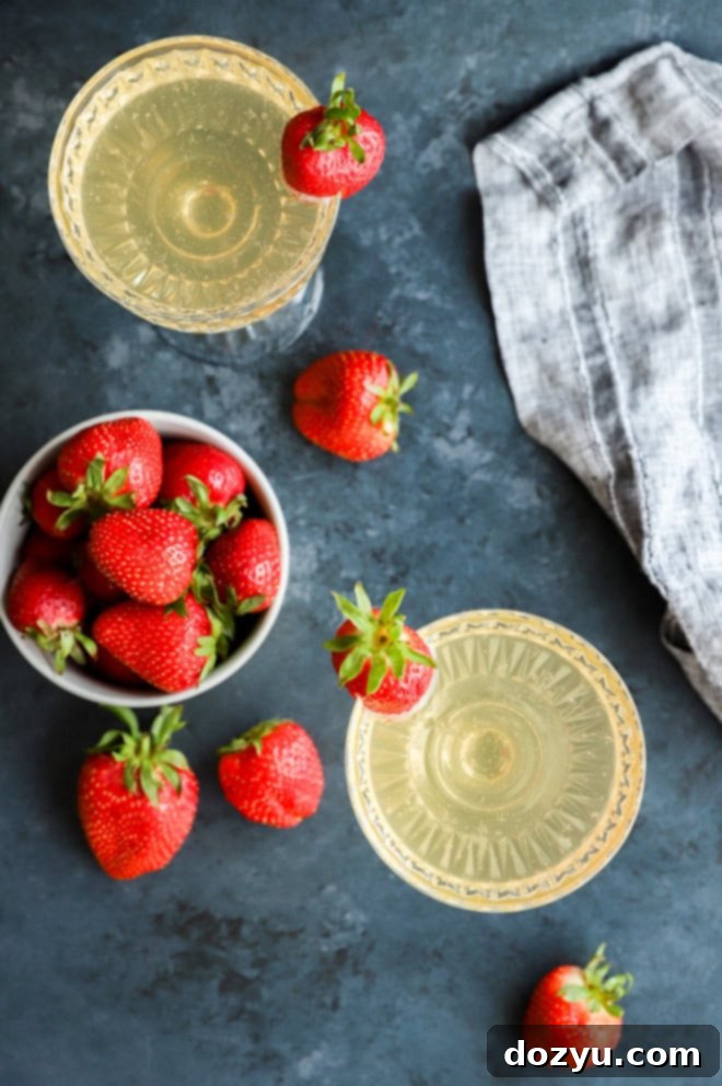 Strawberry Celebration Sparkle 5 strawberry champagne cocktail in coupe glasses with fresh strawberries
