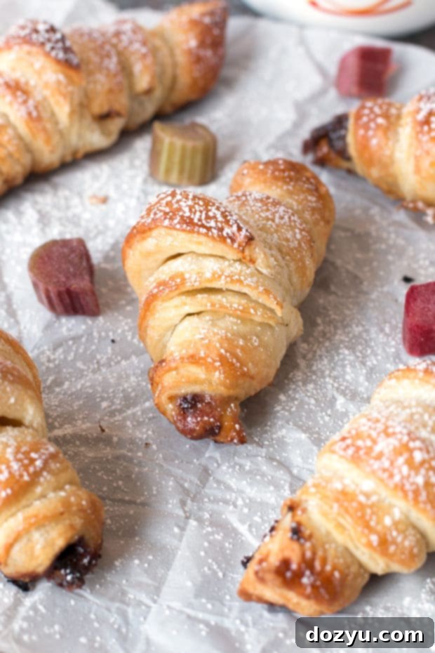 A stack of golden Nutella Rhubarb Puff Pastry Croissants on a wooden board | cakenknife.com #breakfast #brunch #pastry