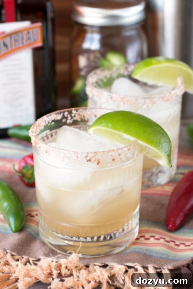 Zesty Heat Margarita 2 Chili Lime Margarita with a chili salt rim and lime wedge garnish